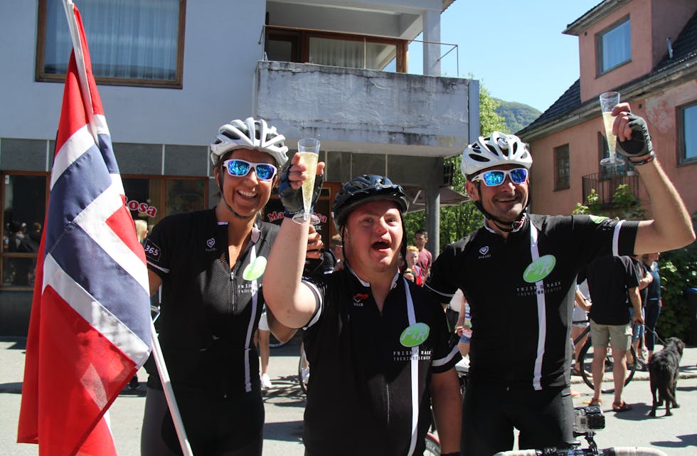 TEAM BREDE: Brede Svendsen, her omkransa av lagkameratane sine, Gunn Bastlien og Paul Kåre Handeland, feira sykkelprestasjonen med jubel, shampis og flagg. (Foto: Ingvil Bakka)