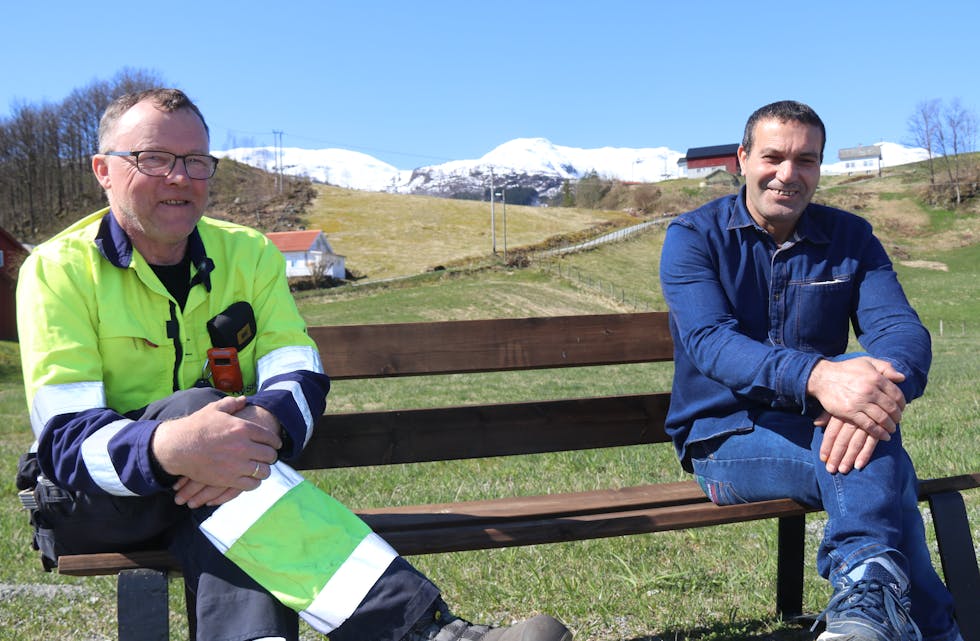 Arbeidsleiar Kjell Vidar Hovland (til venstre) og arbeidssøkar Ali Alfandi på benken som står ved avkjørsla mot Fosstveit. 