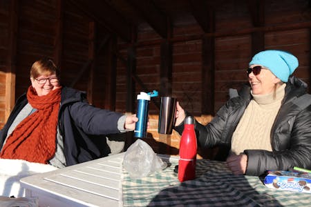Gunn Lunde (til venstre) og Berit Svantesen tar gjerne ein kaffiskål i sin eigen private utandørs ”kafe” i Saudasjøen. 