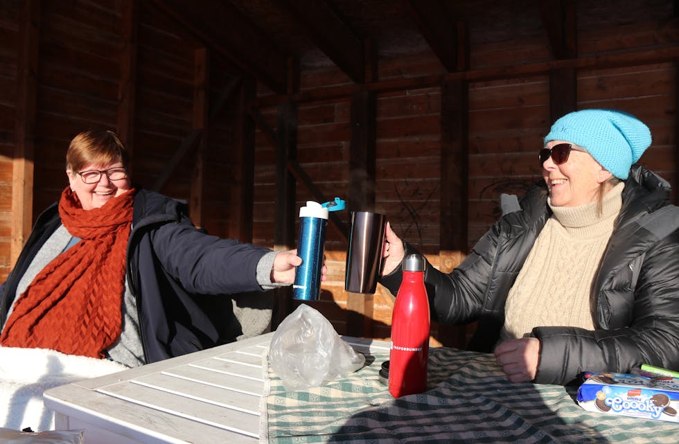 Gunn Lunde (til venstre) og Berit Svantesen tar gjerne ein kaffiskål i sin eigen private utandørs ”kafe” i Saudasjøen. 