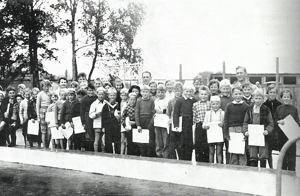 Wilhelm Handegård og Marthon Jensen saman med deltakarane på svømmekurs.