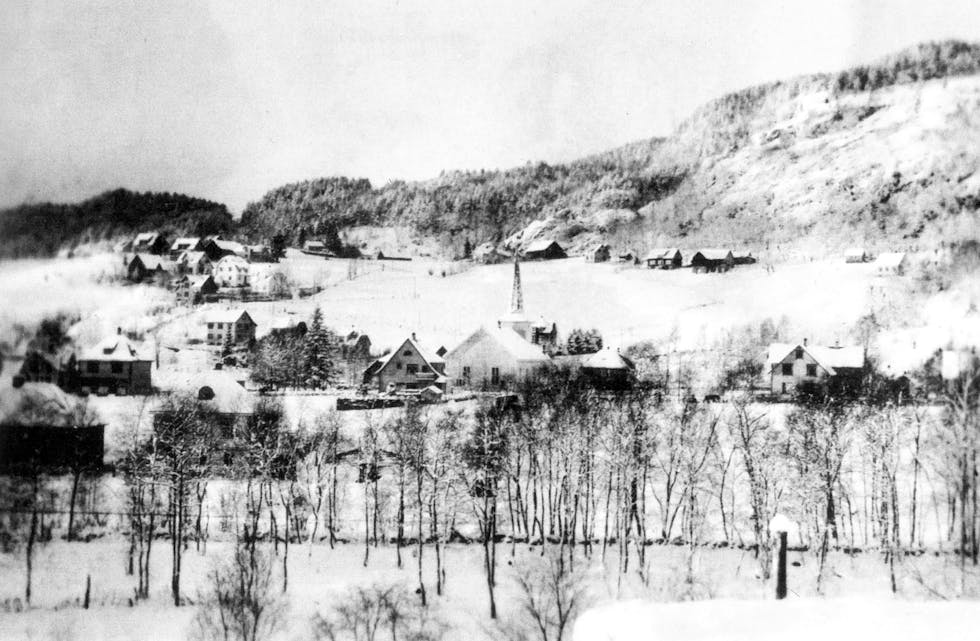 Sauda kyrkje og husa omkring med Fløgstad-gardane i bakgrunnen, fotografert under krigen.