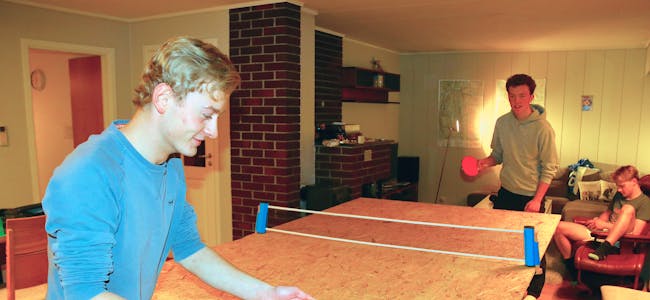 Å kunne spele bordtennis i stova er både praktisk og triveleg, ifølge dei tre idrettsfag-elevane Tobias Helgeland (nærmast), Magnus Tveit og Mats Nordvik (i sofaen) 