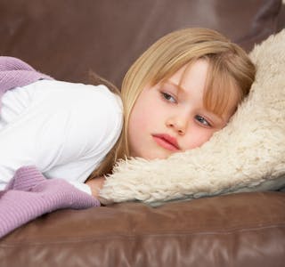 Young Girl Unwell Lying On Sofa