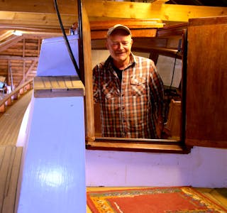 Bak dører av kirsebærtre tittar Einar Andreassen fram frå båten han har brukt meir enn to tiår på å bygge. No ser han fram til sjøsetting denne sommaren. 