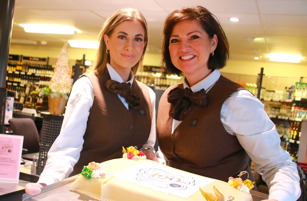 Stine Søndenå og butikksjef Siri Gauthun (høgre) feira Vinmonopolets 100 års-jubileum med kake og alkoholfrie bobler til kundane.