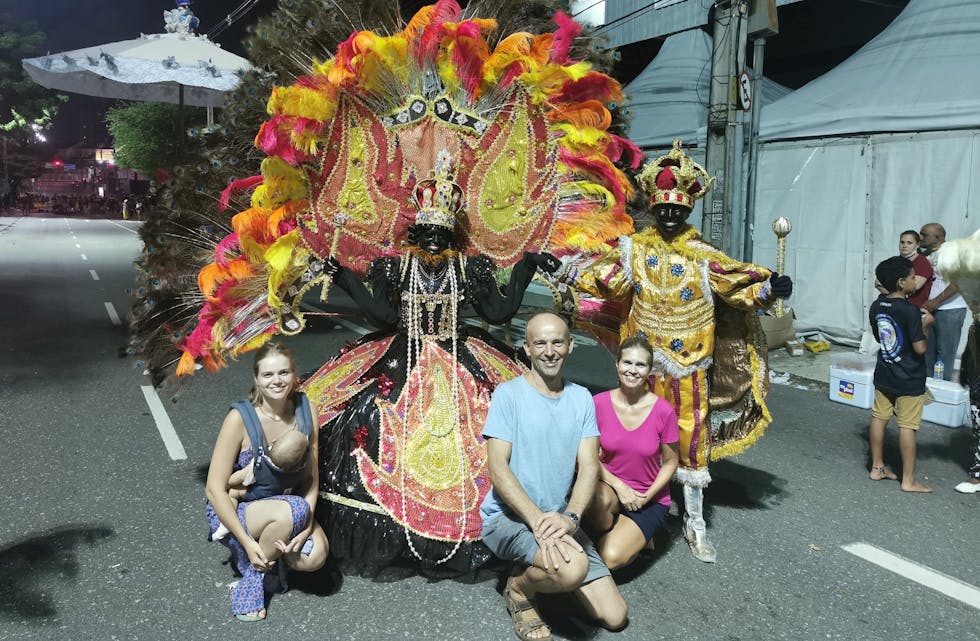 Anna Selvik Andrade med vesle Eloise, Rune Selvik og Synnøve Selvik avbildet sammen med ein karnevalspyntet brasilianer.