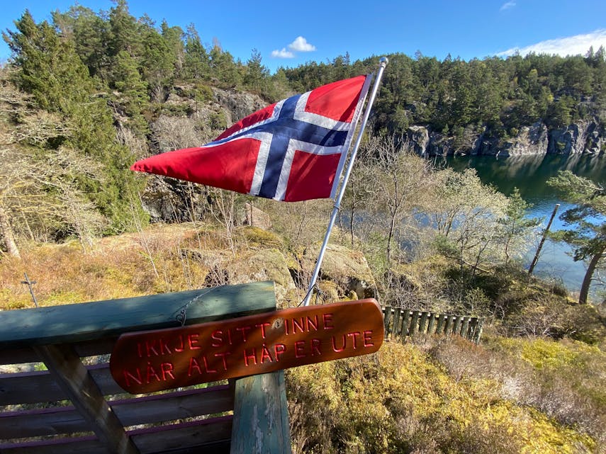 Flagget vaiar i den kalde aprilvinden på hytta i Bjødnavågen, Ropeidhalvøya. Likevel: Ikkje sitt inne når alt håp er ute! 