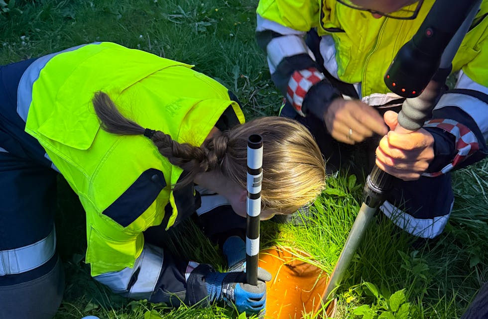 Her greier brannfolka André Håheimsnes og Ida Øverland å redde eit uheldig pinnsvin frå eit djupt dreneringshol.