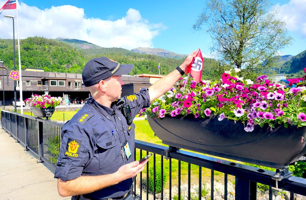 Politiet fjernar seks nazi-flagg frå blomsterpottene på brua over Nordelva onsdag føremiddag.